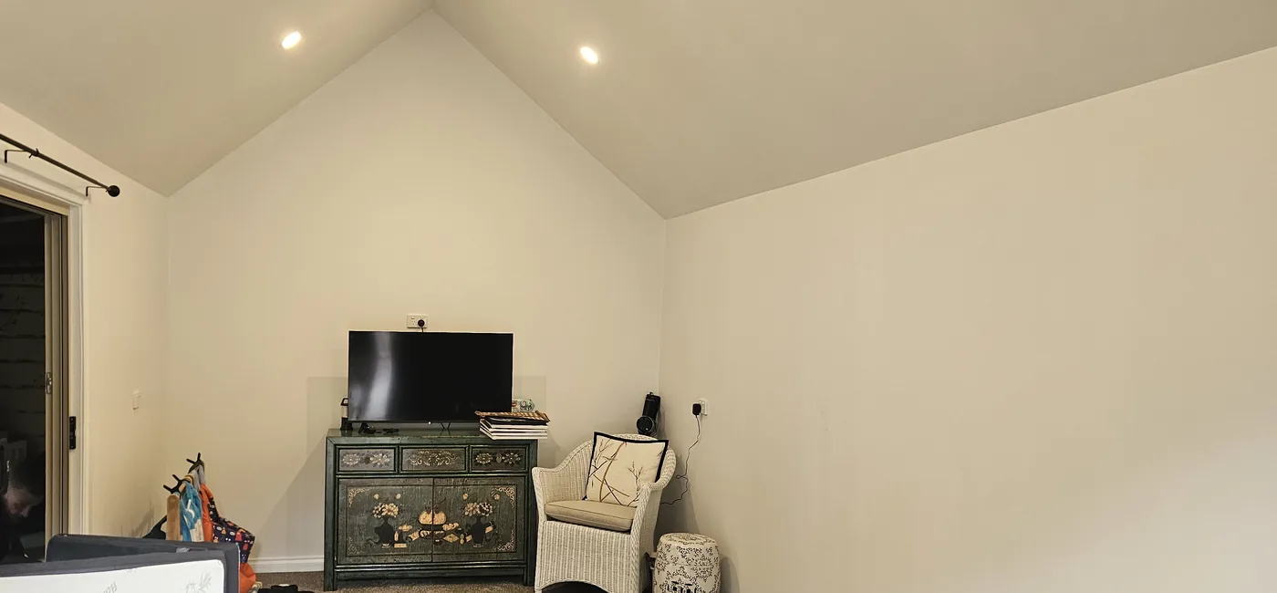 Inside the studio: a raked white ceiling with downlights and a sliding glass door