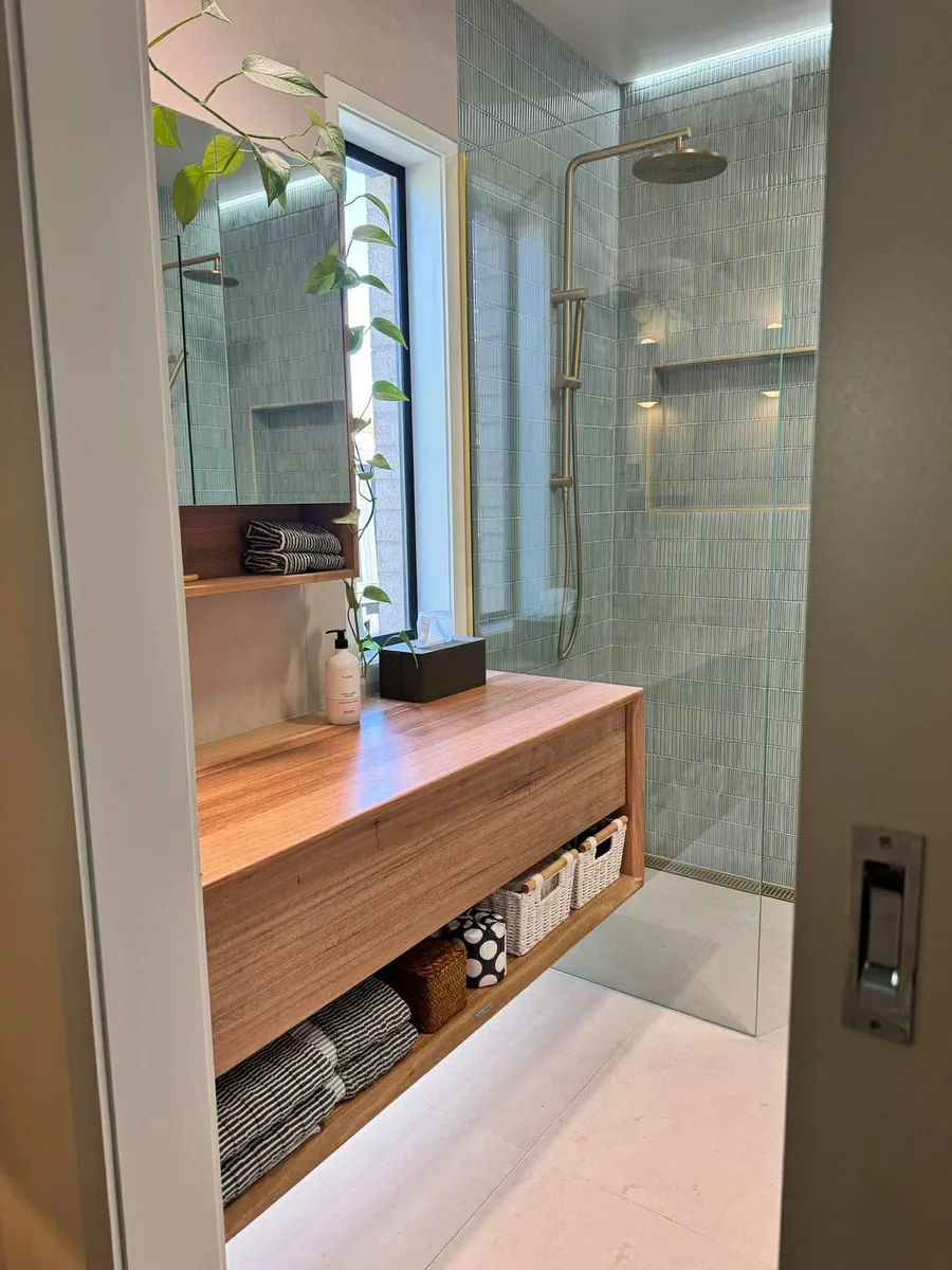 Bathroom with a timber vanity, open shelving and a tiled walk-in shower